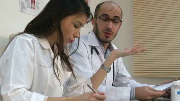 Genç hemşire ve erkek doktor ofisinde tartışıyor — Stok video