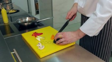 Patlıcan kesme ve bir wok tavada doğranmış sebze koyarak Şef