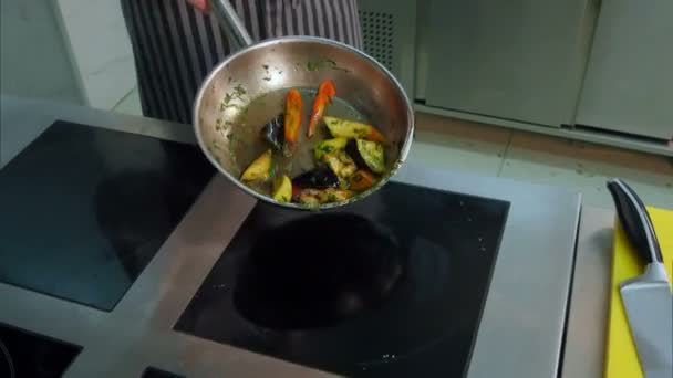 Chef expérimenté jetant et retournant des légumes dans une poêle — Video