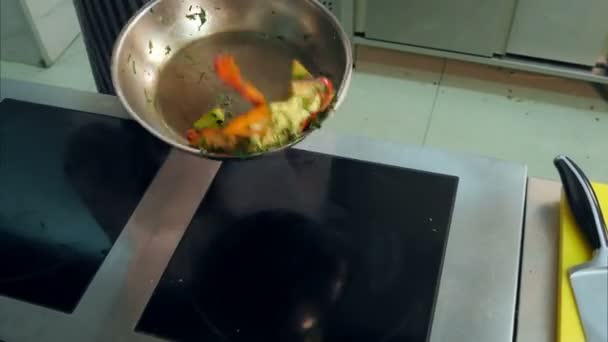 Chefs mains jetant des légumes dans une casserole wok — Video