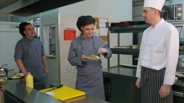 Jeunes cuisiniers masculins essayant la salade de crevettes cuisinée par le chef — Video