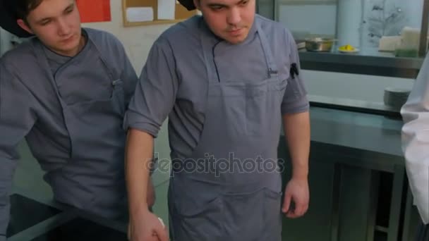 Chef showing his assistants how to choose oranges for seafood appetizer on a white plate — Stock Video