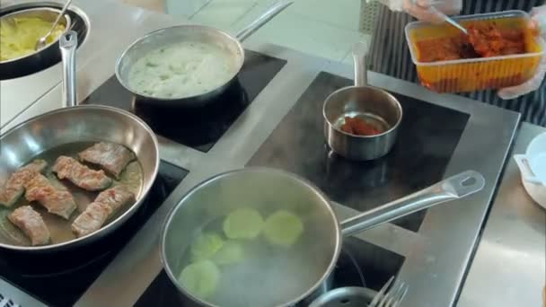 Σεφ τα χέρια βάζοντας κόκκινη σάλτσα λαχανικών σε κατσαρόλα στο φούρνο — Αρχείο Βίντεο
