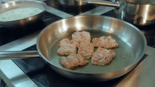 Meat being fried in a frying pan on the stove — Stock Video