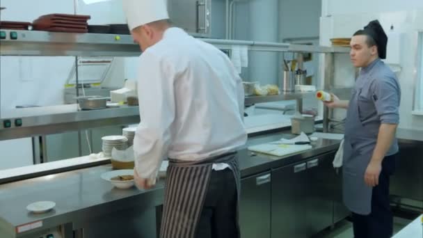 Chef e cozinhar molhos verter para prato preparado — Vídeo de Stock