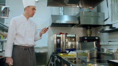 Bir şey onun telefonundan okuma ve bir aşçı stajyerler için konuşuyor Şef