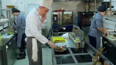 Baş şef telefon konuşma yaparken Restoran mutfakta yemek