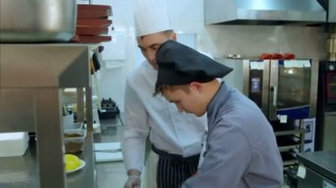 Cook stajyer bir tabakta sebze hizmet öğrenme