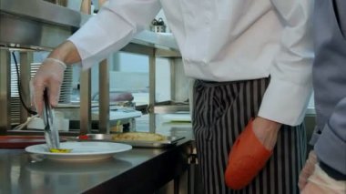 Şef Aşçı stajyer düzgün pişmiş çanak hizmet kullanmayı öğretmek