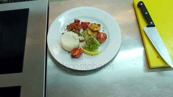 Кухарі руками додають соус до рису з овочами на тарілці — стокове відео