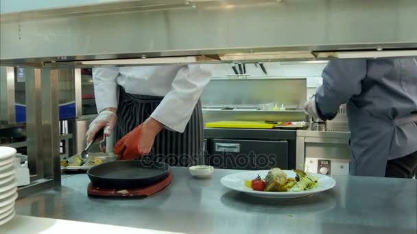 レストランのキッチンで料理をしての仕事で忙しい二人のコック — ストック動画