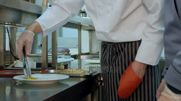 Chef ensino cozinheiro trainee como servir o prato cozido corretamente — Vídeo de Stock