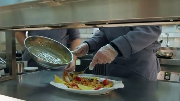 Chef-koks mannelijke handen dressing gekookte garnalen en groenten op een plaat met saus — Stockvideo