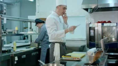 Beyaz üniforma yeni yemek siparişi okurken Evet içinde baş şef