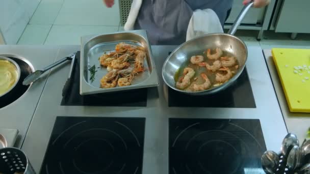 Chef acrescentando sal e alho a camarões fritando em uma panela — Vídeo de Stock