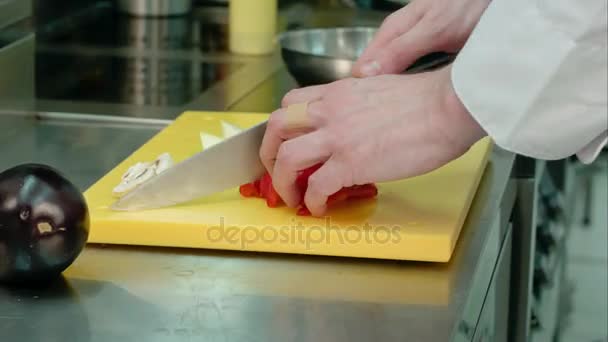 Руки поваров режут красный сладкий перец — стоковое видео
