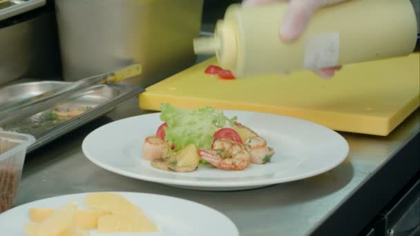 Chefs mãos masculinas adicionando molho e especiarias para salada fresca com camarões — Vídeo de Stock