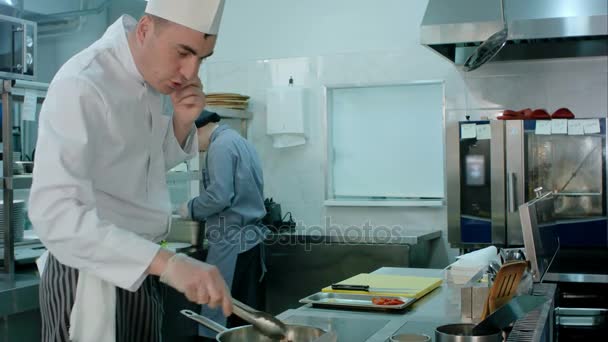 Baş şef telefon konuşma yaparken Restoran mutfakta yemek — Stok video