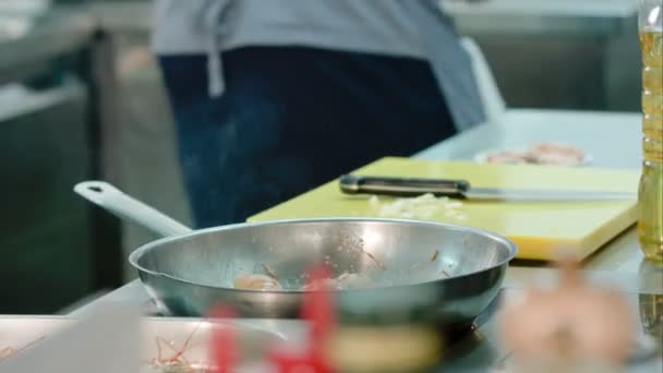 Gamberetti che vengono sparati su una padella mentre chef fa qualcosa in cucina — Video Stock