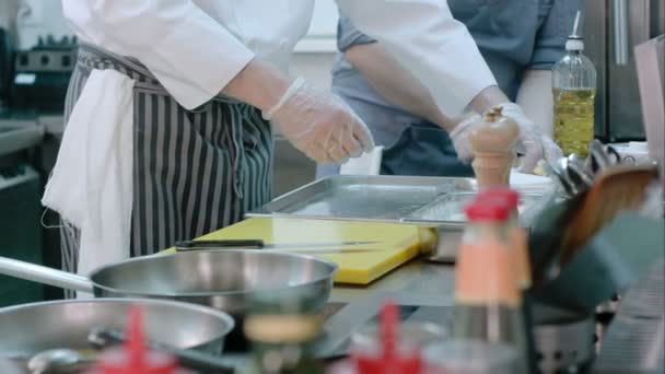 Cozinheiro masculino colocando peixes farinhados em uma bandeja — Vídeo de Stock