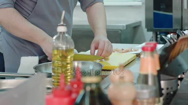 Ervaren man kookt handen hakken knoflook op een plastic bord — Stockvideo