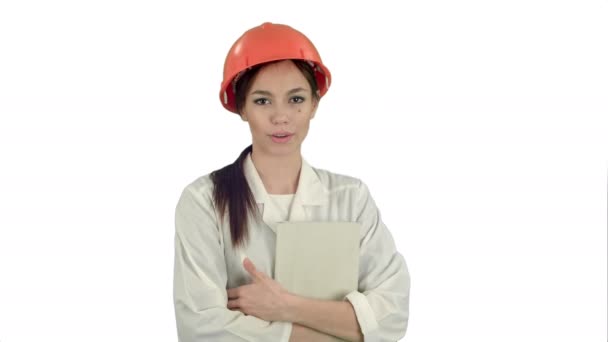 สถาปนิกหญิงในหมวกแข็งถือแท็บเล็ตพูดคุยกับกล้องบนพื้นหลังสีขาว — วีดีโอสต็อก