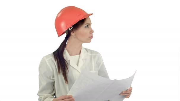 Unga kvinnliga arkitekt hålla ritningar och kontrollera byggandet på vit bakgrund — Stockvideo