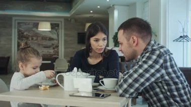 Aile Enjoying çay içinde Cafe birlikte. Baba ve anne onların kızı arıyorum.