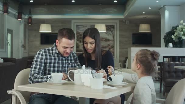 Dochter probeert aandacht te trekken ouders terwijl ze zijn druk op zoek in de tablet. Ze keek verveeld. — Stockvideo