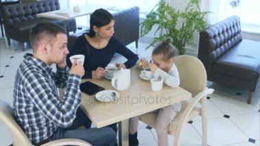 Konuşmak için telefon ile karısı ve kızı kafe ya da Restoran otururken babası. Annesi ona kızgın arıyorsunuz.