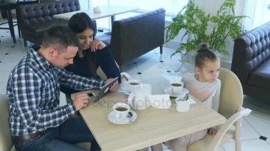 Kızları kafede onların dikkatini çekmek isterken tablet vasıl seyir ebeveynler harcama zaman.