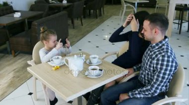 Modern kız güzel ailesi fotoğraflarını kafede çeker..