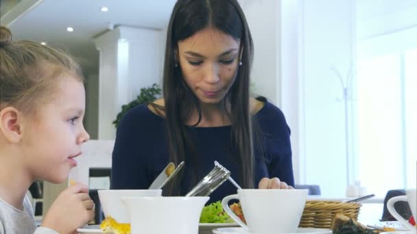 Europese harmonieuze familie gezond lunchen in café. Ze eten fruit salade, chatten en glimlachen. — Stockvideo