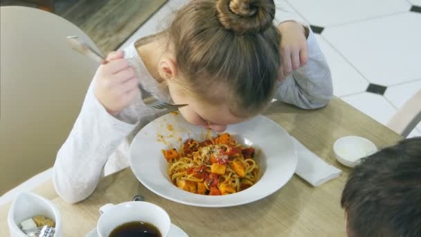 Little grimy girl eating careless her pasta in cafe. — Stock Video