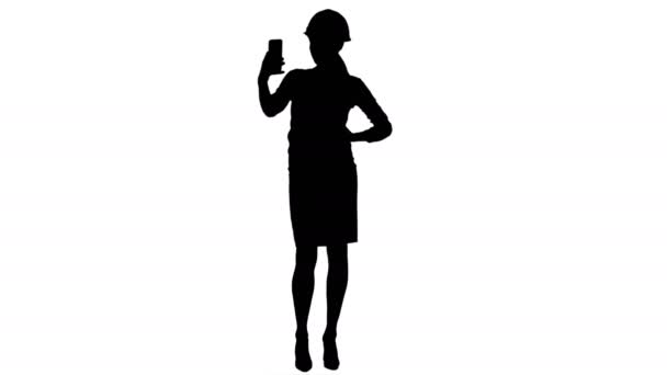 Sylwetka młody architekt kobiece w kasku robienia selfie na telefon — Wideo stockowe