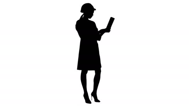 Silhouette Female engineer in helmet having video call via tablet — Stock Video
