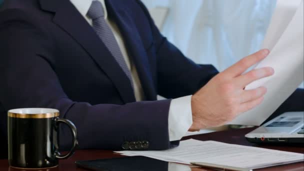 Empresario firmando documentos con una taza de café sobre la mesa — Vídeo de stock