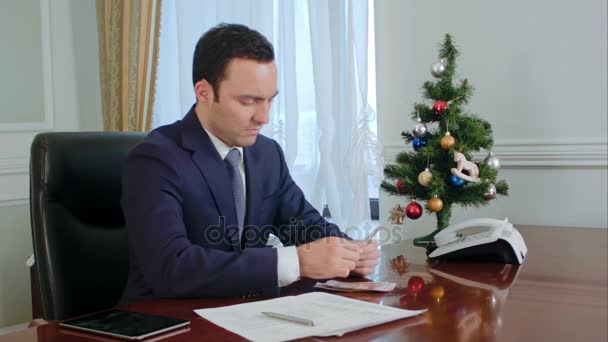 Disappointed young businessman counts money before Christmas — Stock Video