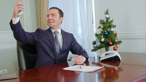 Jefe tomando selfies divertidos con árbol de año nuevo, sonriendo — Vídeos de Stock