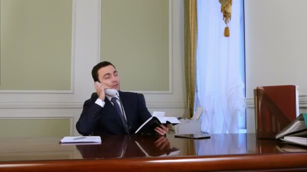 Busy young businessman talking landline phone having partnership conversation in office — Stock Video