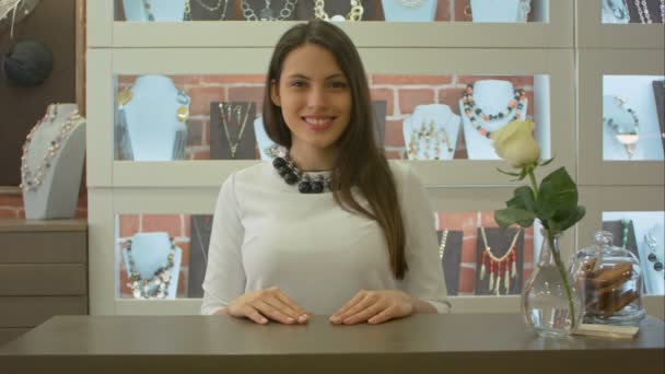 Amigável vendedor feminino bonito sorrindo, olhando para a câmera em uma loja de jóias — Vídeo de Stock