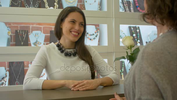 Jonge vrouwelijke verkoper voldoet aan en luistert naar de koper die net naar juwelenwinkel komt — Stockvideo