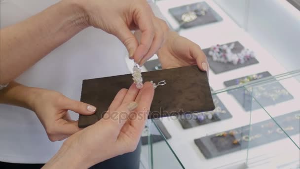 Pendientes de mujer en plata con gemas blancas en la joyería — Vídeo de stock