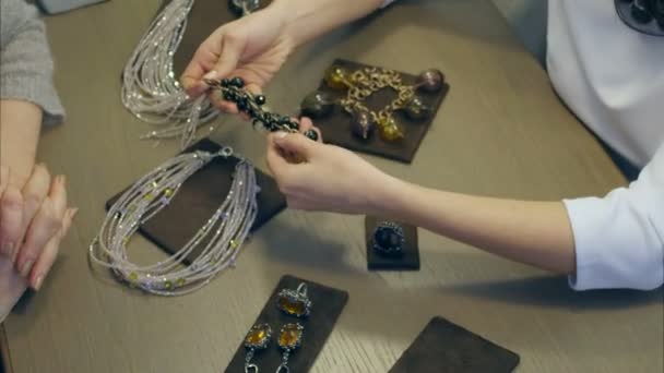 Kobiece sprzedawca pomaga eleganckiej kobiety przymierzyć drogich bransoletka — Wideo stockowe