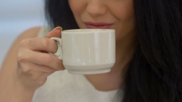 Mujer joven bebiendo té y sonriendo — Vídeos de Stock
