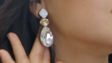 Genç kadın güzel dimond küpe ve gülümsüyor koyar