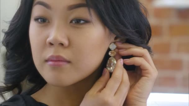 Jonge Aziatische vrouw zet op prachtige Oorhangers — Stockvideo