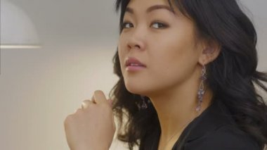 Güzel Asyalı kadın tebessümle pencereden bakıyor