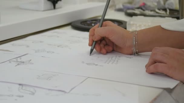 Sieraden ontwerper s hand schetsen van ontwerpen in studio — Stockvideo