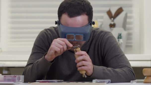 Joalheiro olhando para o anel de dimond através de óculos em uma oficina — Vídeo de Stock
